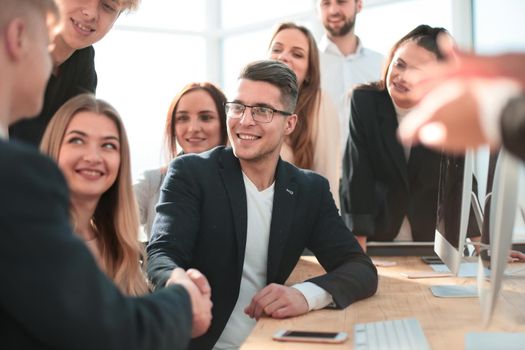 Manager congratulating a young employee in the workplace. success concept