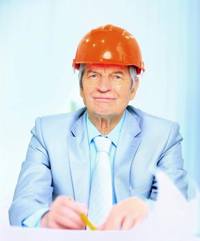 Engineer at the age of considering plans drawing and corrects them.