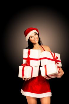 Santa hat Christmas woman holding christmas gifts smiling happy and excited. Cute beautiful multi-racial Caucasian Asian santa girl isolated on black background.