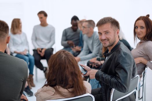 close up. handsome young man sitting in a circle of his like minded