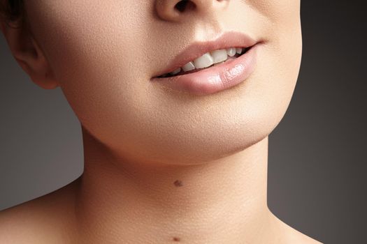Wide smile of young beautiful woman with perfect healthy white teeth on grey background. Dental whitening, ortodont, care tooth and wellness. Natural makeup on perfect face.
