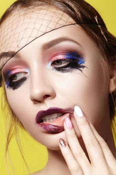 Dramatic Fashion Look young Woman. Beautiful Model with bright Make-up. Makeup style for Halloween on yellow background