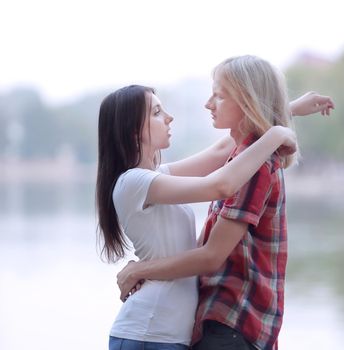 young people in love standing on the lake shore.