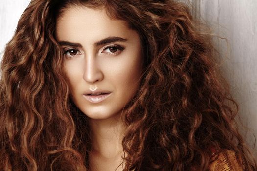 Beautiful young woman with long curly hairstyle, fashion jewelry with long brunette hair. Sexy girl in vogue style. Pretty arabian beauty portrait of female face. Indian style clothes, long dress