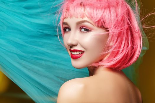 Young model in pink wig. Beautiful model with fashion makeup. Bright spring look. Sexy hair color, medium hairstyle with blue fabric