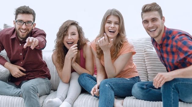 group of cheerful friends watching their favorite movie, sitting on the couch