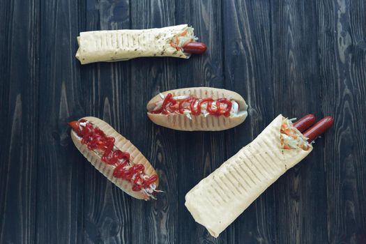 fast food.hot dog with spicy sauce and Shawarma on dark background.
