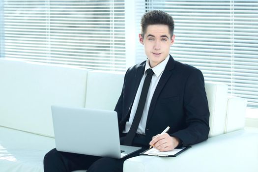 confident businessman working on laptop sitting in the spacious office.photo with copy space