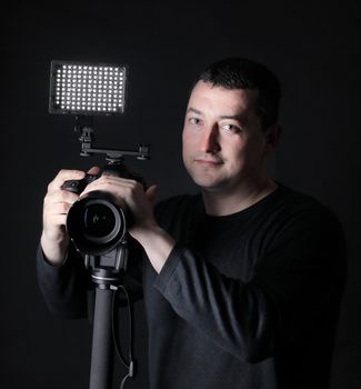 professional photographer with camera on tripod.isolated on black background.