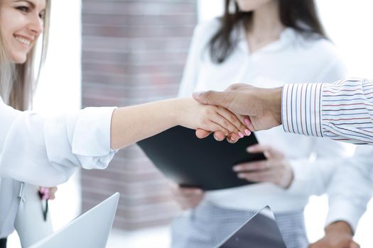 closeup.handshake business colleagues on the background of the office.the concept of partnership