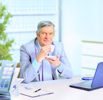 The businessman at the age of drinking coffee during the break.