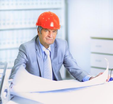 Engineer at the age of considering plans drawing and corrects them.