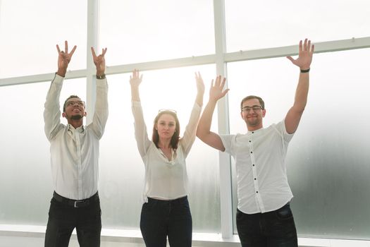 successful business team stands with hands up. photo with copy space