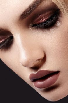 Close-up Portrait of Beautiful Woman Face on dark Background. Fashion Evening Make-up, Glitter Eyeshadows, Matt Lips, Shiny Clean Skin. Sexy Woman Style