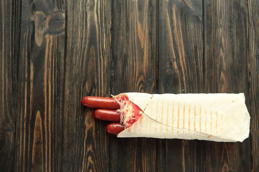 spicy sausages in pita bread on wooden background.photo with copy space.