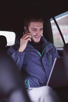 closeup. business man uses a laptop and mobile phone sitting in the car