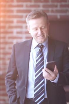 senior businessman reading text message on smartphone.people and technology