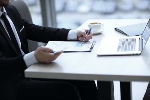 closeup.businessman checking financial statement,sitting at the Desk in the office