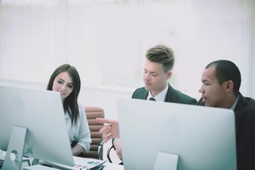 business team talking while sitting at a Desk in a modern office