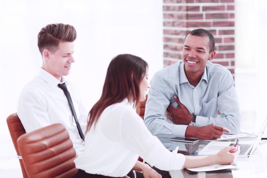 employees talking to a customer sitting at the Desk in the office.