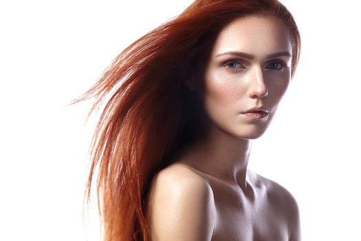 Beautiful ginger young woman with flying hair and naturel makeup. Beauty portrait of sexy model with straight red hair. Long soft shiny hairstyle. Close-up studio shot o fashion look redhead girl