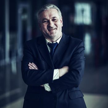 successful businessman in a business suit on background of modern office