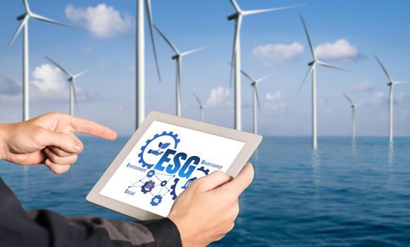 Green business transformation for environment saving and ESG business concept. Businessman using tablet to set corporate goal toward environmental friendly management and alternative clean energy use.