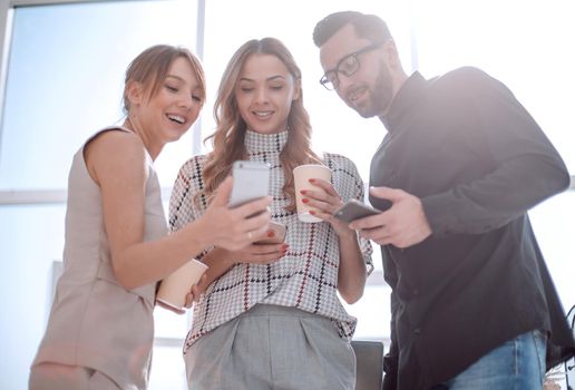 close up.business team looking at the screens of their smartphones.