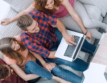 view from the top. the group of friends with a laptop,discussing the video