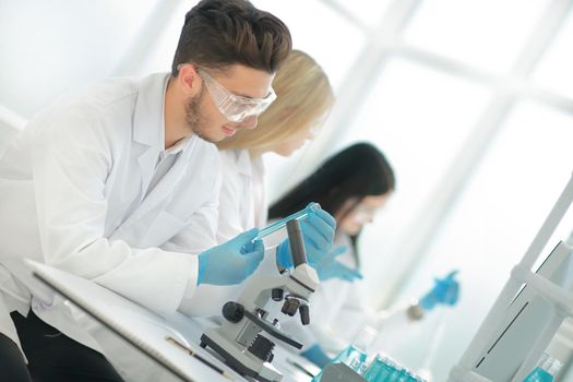 group of young biologists sitting at the laboratory table. science and health
