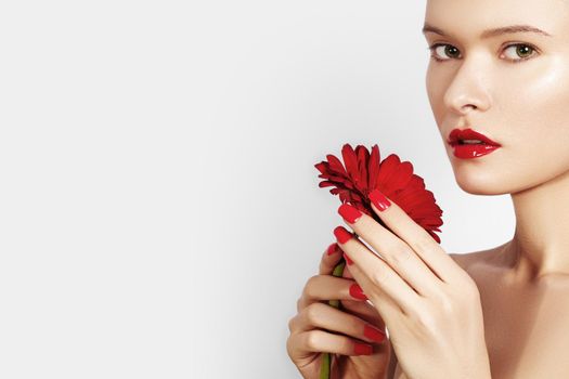 Close-up Beauty portrait sexy Woman with Red Lips, Lipstick, Manicure and Beautiful Red Flower. Spa Clean Skin. Salon Make-Up