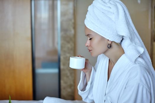 Beautiful Luxury Life. Breakfast. Happy Girl with a Cup of Coffee. Home Style Relaxation Woman Wearing Bathrobe and Towel after Shower. Spa Good Morning.
