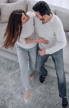 laughing couple having fun on the couch in the living room.the concept of happiness