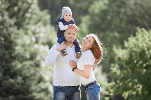 happy family with a young son in the background of a summer Park. photo with copy space