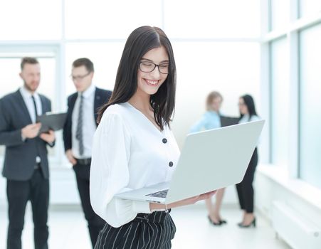 business woman with laptop standing in Bank lobby.photo with copy space