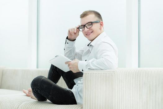 smiling guy looking through media files on his tablet.photo with copy space