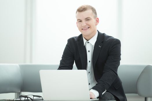 businessman working on a laptop in the lobby of a modern hotel. people and technology