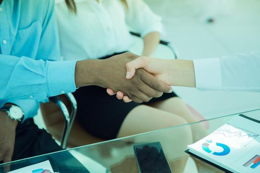 closeup.the financial partners shaking hands over a Desk.the concept of profitable partnerships