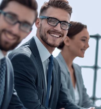 side view.a group of employees sitting at the Desk.photo with copy space