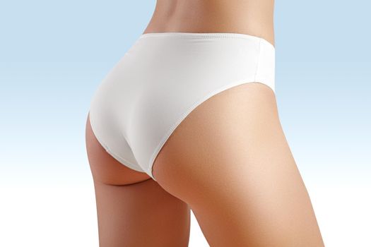 Spa and wellness. Healthy slim body in white panties. Beautiful sexy hips. Fitness or plastic surgery. Perfect buttocks without cellulite.