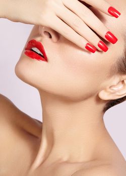 Red lips and bright manicured nails. Sexy open mouth. Beautiful manicure and makeup. Celebrate make up and clean skin. Kiss