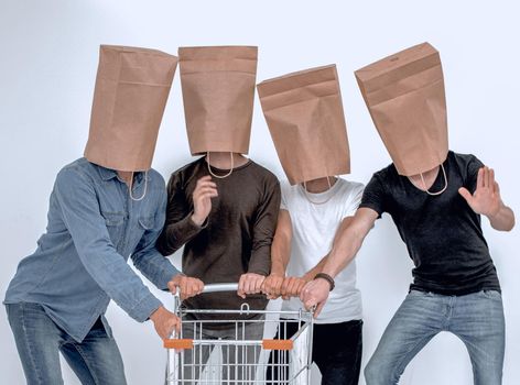 men with paper bags on head and shopping cart in hands on isolated background