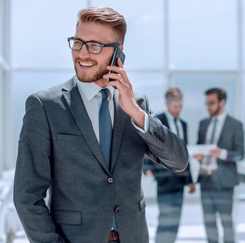 businessman with mobile phone standing next to the Bank office .photo with copy space