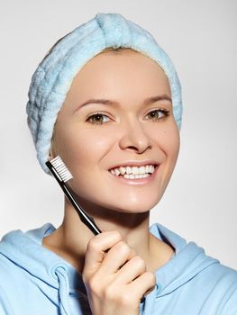 Beautiful Woman with Great Teeth holding Tooth Brush. Daily Routine Teethcare Treatment for Perfect Happy Smile. Joyful Girl in Bath Headband