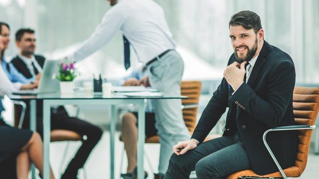 Manager on the background of business team working in office.the photo has a empty space for your text