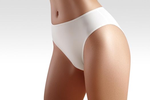 Spa and wellness. Healthy slim body in white panties. Beautiful sexy hips with clean skin. Fitness or plastic surgery. Perfect buttocks without cellulite.