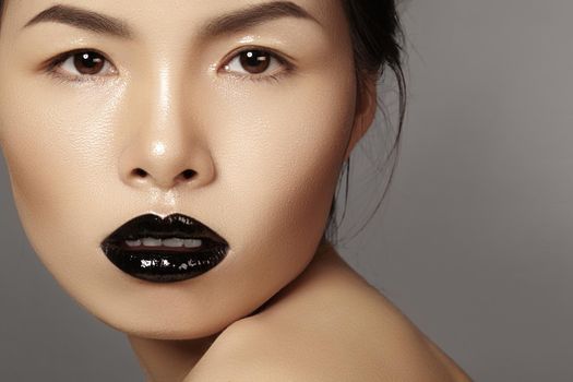 Perfect asian model with fashion make-up with dark lipstick and gloss. Beauty halloween style with black lips makeup. Catwalk visage
