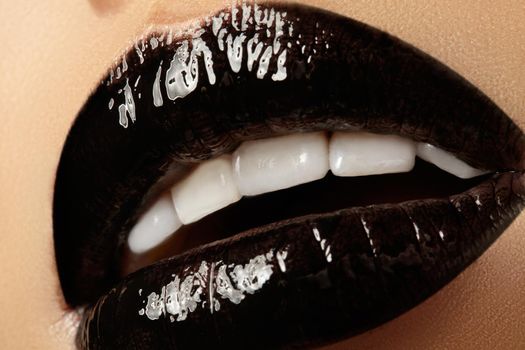 Black glossy lips makeup. Macro beauty shot of face part. Halloween look with black lipstick with gloss