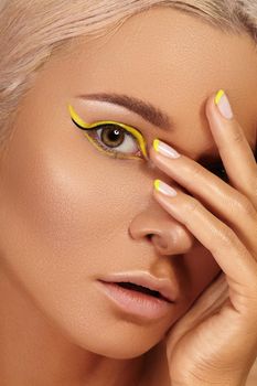 Beautiful close-up portrait of tanned skin woman. Sunburnt girl face with natural boho bronzed make-up and yellow manicure. Sexy summer style makeup