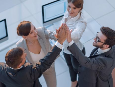 successful business team giving each other a high-five, standing in the office.concept of success.